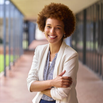 Portrait Of Smiling Female Elementary School Teacher Outdoors At School